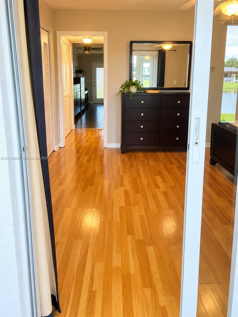 Wood-finish flooring, white sliding glass door, and interior paneled doors