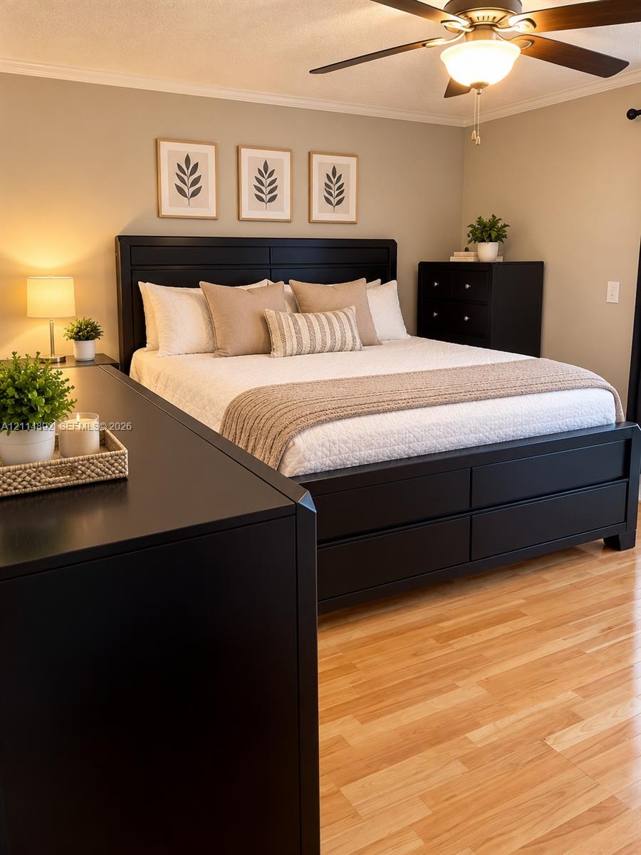 Neutral-toned walls paired with wood-finish flooring and a ceiling-mounted light fixture with a central fan