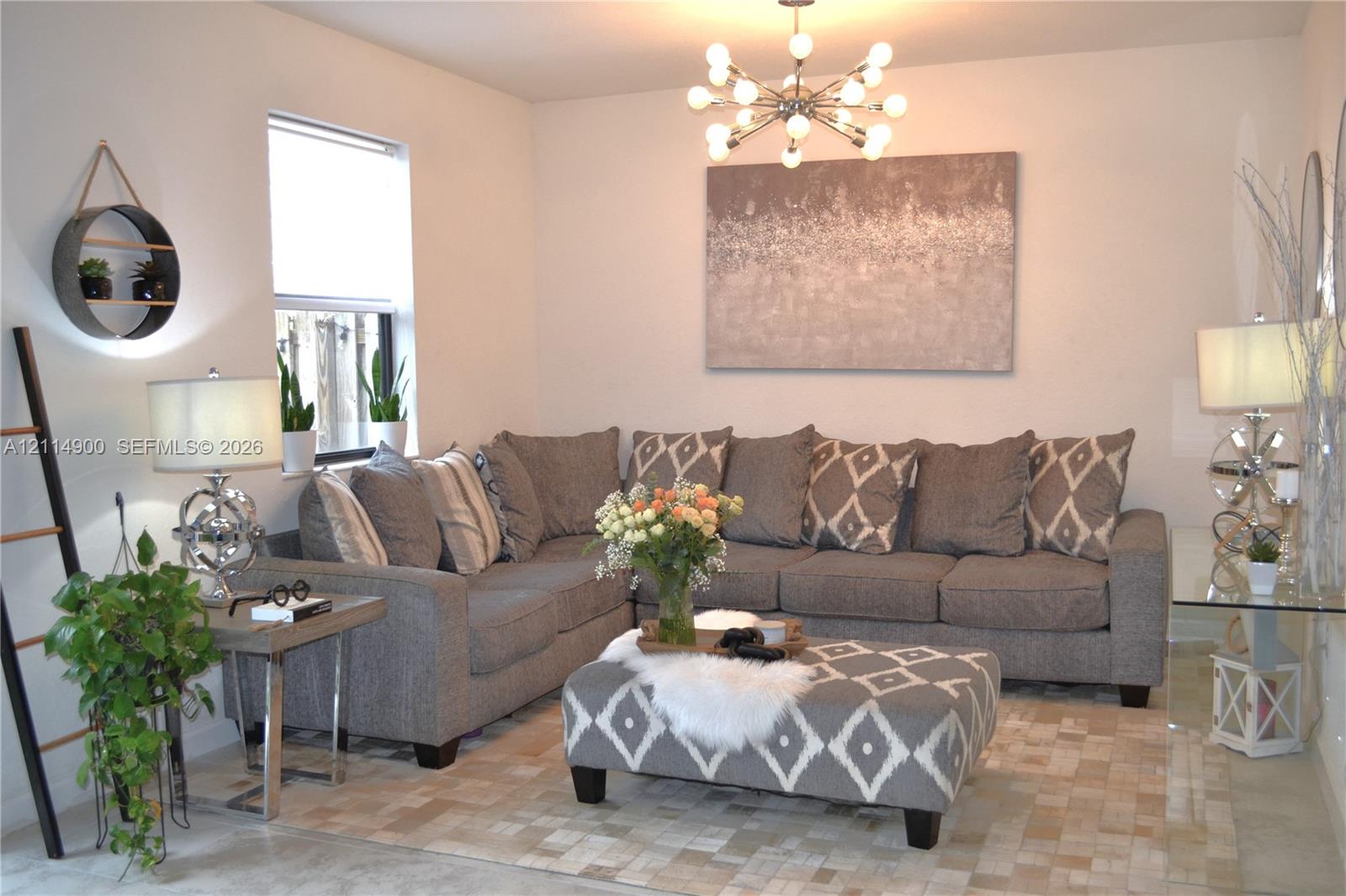 Modern multi-bulb sputnik chandelier, neutral wall finish, and natural light via a single-pane window