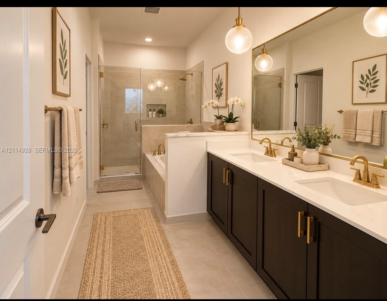 Double vanity featuring dark cabinetry, solid surface countertops, and gold-tone fixtures, complemented by a walk-in glass-enclosed shower, built-in soaking tub, and pendant lighting