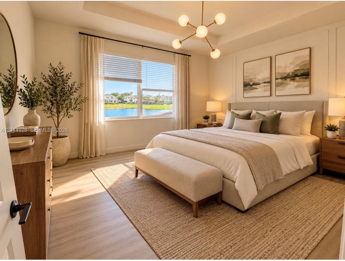 Tray ceiling, modern multi-arm chandelier, wood-finish flooring, paneled accent wall, and window with water backdrop