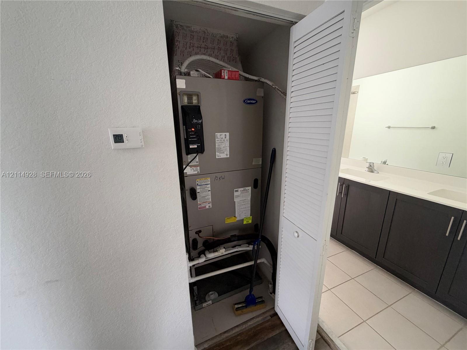 Carrier HVAC system housed in a utility closet with louvered door access