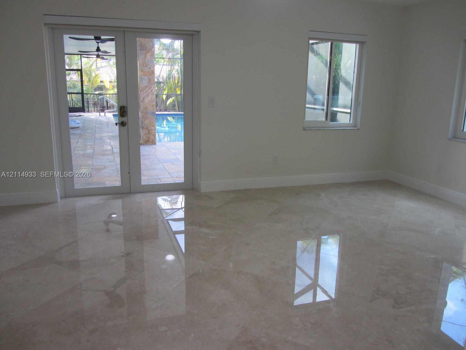 Polished stone flooring, double-pane sliding glass doors, and dual-pane windows