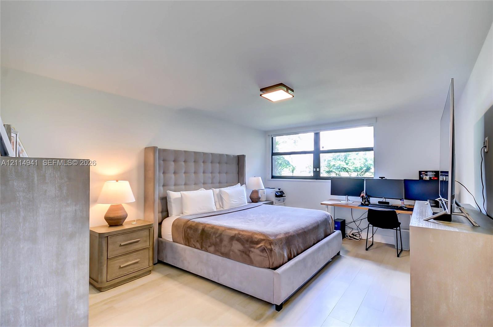 Light-filled room featuring neutral wall finishes, wood-finish flooring, and a flush-mount ceiling light
