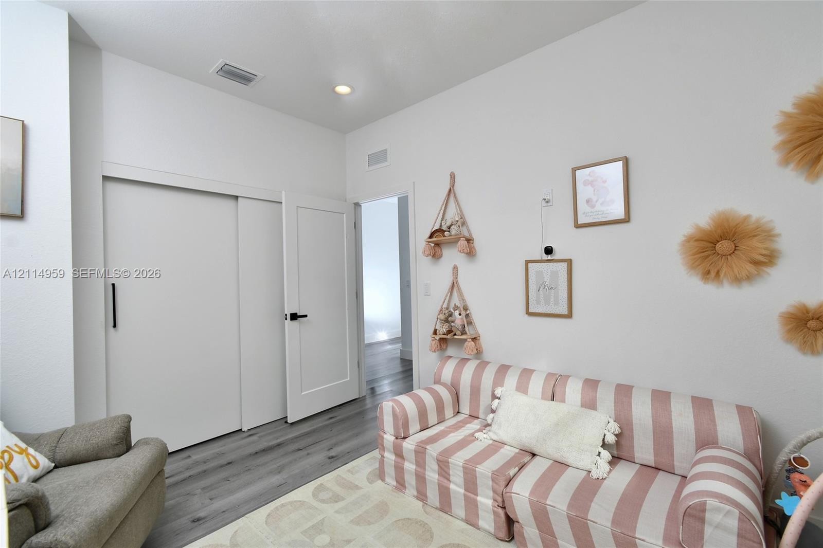 Wood-finish flooring, high ceilings, recessed lighting, and a white interior door featuring matte black hardware