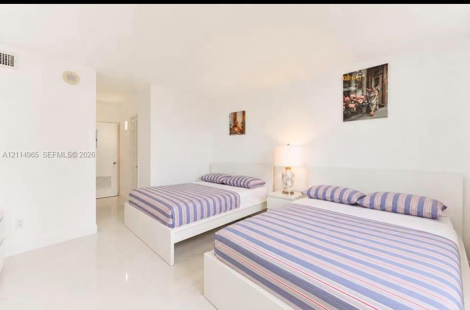 Spacious room featuring high-gloss tile flooring, smooth ceilings, and white wall finishes