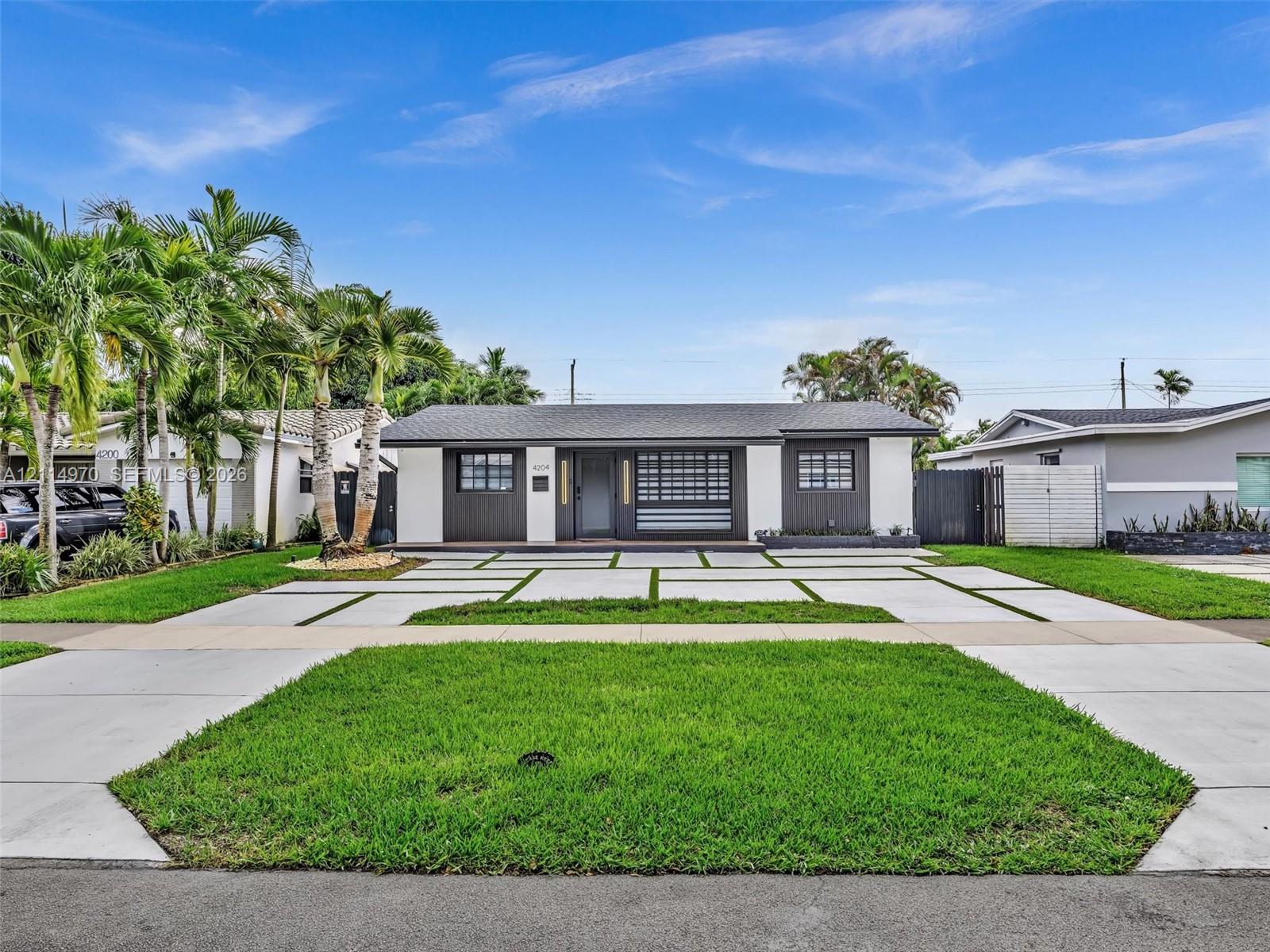 Single-story exterior featuring a high-contrast facade, linear concrete paver driveway with integrated turf, multi-pane accent windows, and mature landscaping