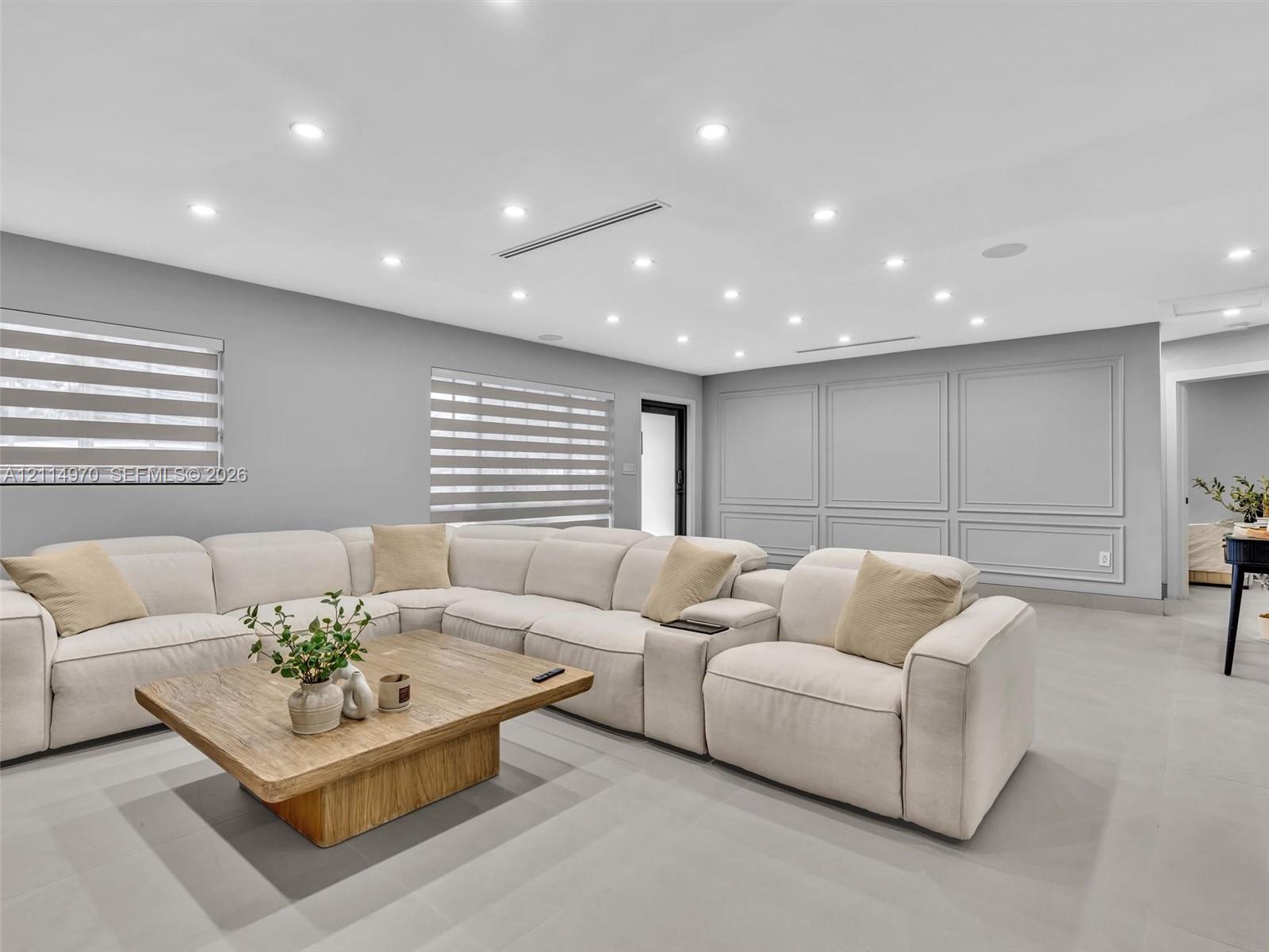 Interior space featuring recessed lighting, paneled wall molding, and dual-shade window treatments Interior space featuring recessed lighting, paneled wall molding, and dual-shade window treatments