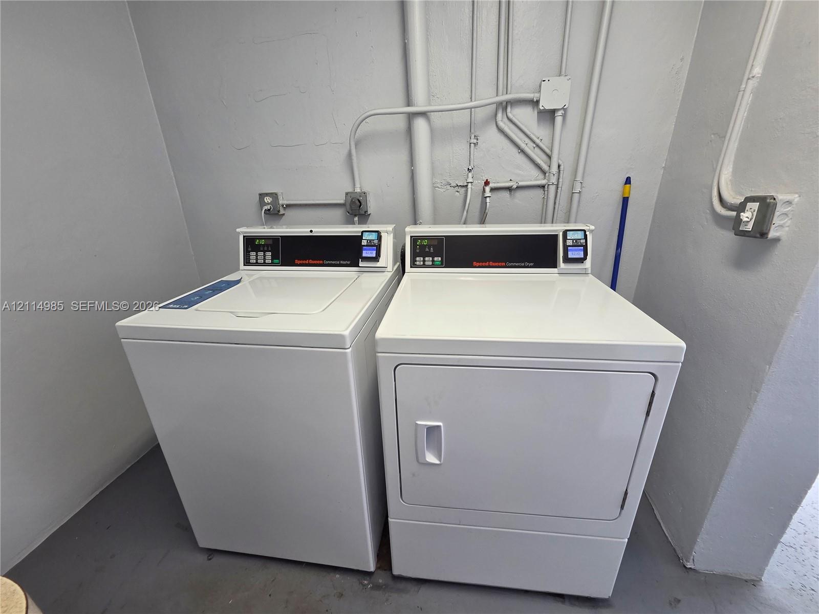 Laundry area featuring top-load washing machine and front-load dryer with white exterior finishes