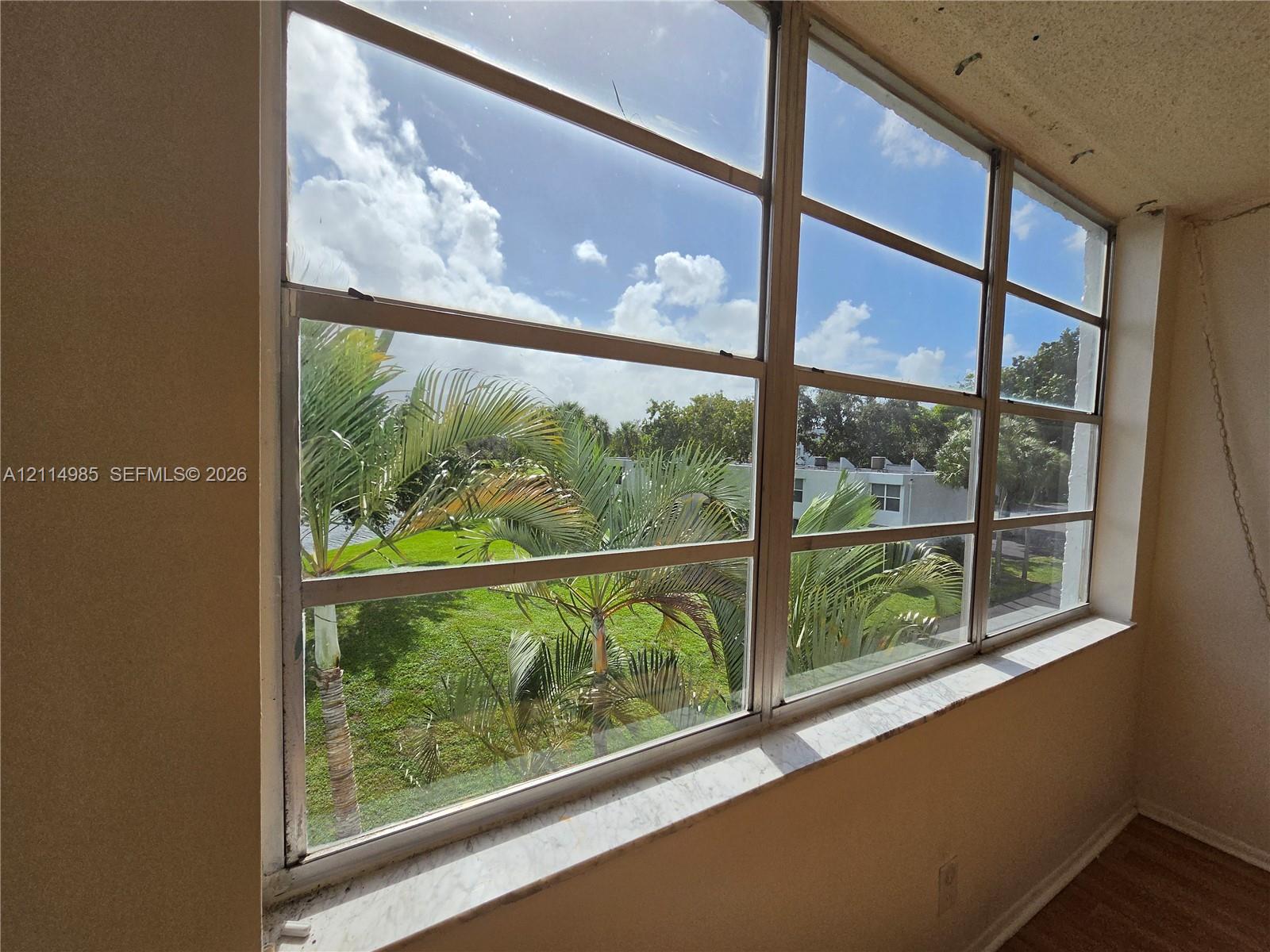 Expansive multi-pane window featuring a deep stone-finish sill and wood-finish flooring