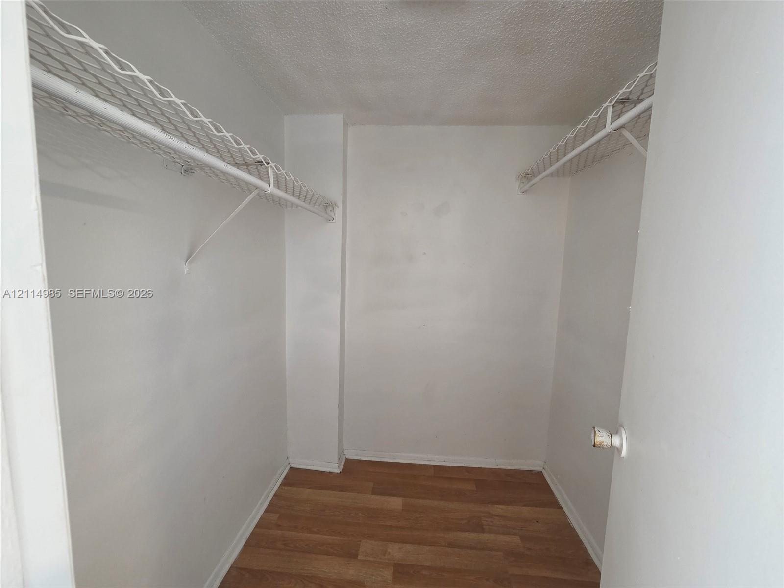 Storage afeaturing wood-finish flooring and dual overhead wire shelving units