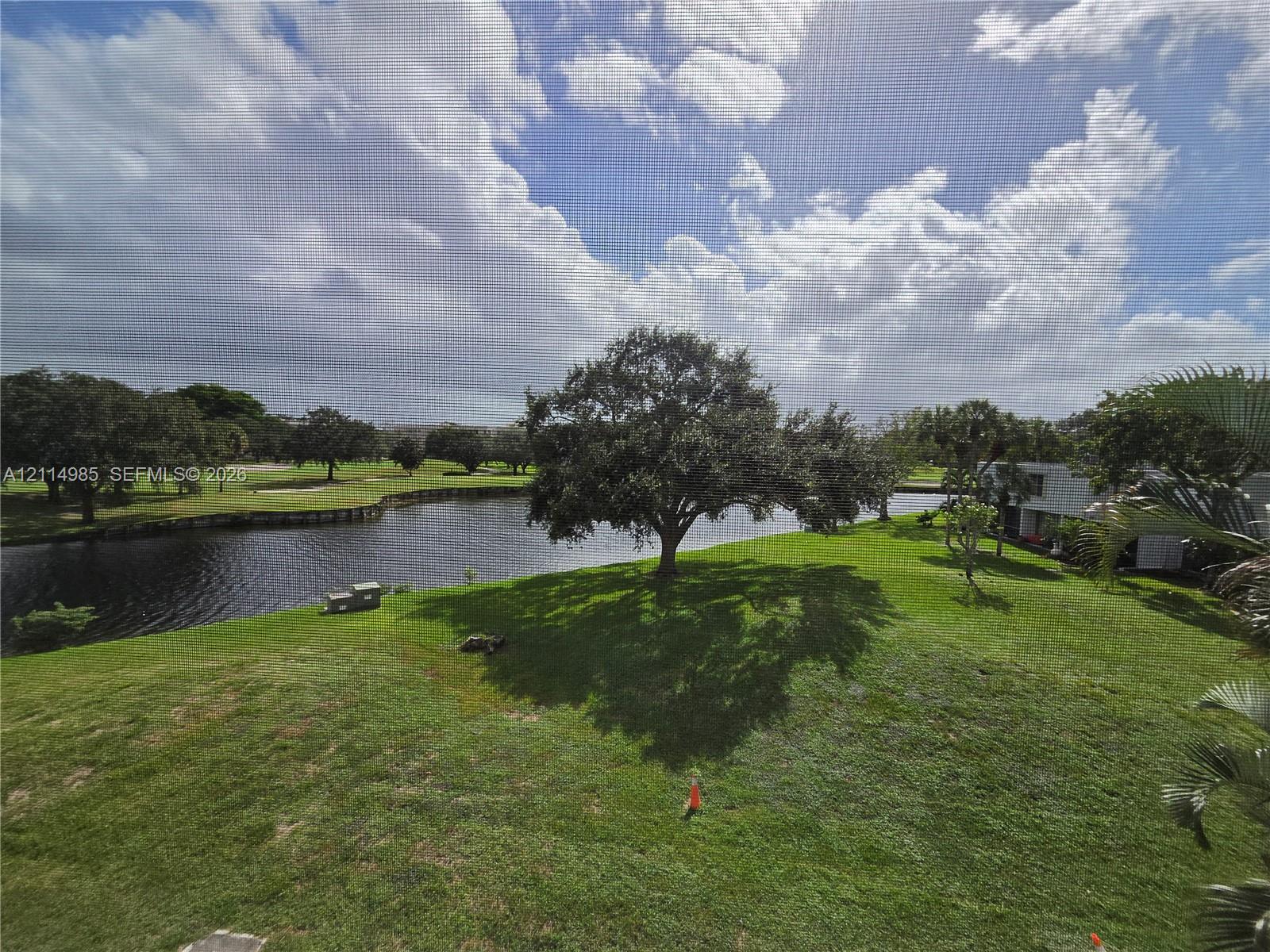 Expansive grounds featuring a water frontage, mature trees, and open green space