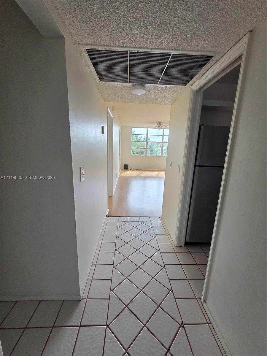 Ceramic tile flooring arranged in a diagonal pattern, wood-finish flooring, and multi-pane window