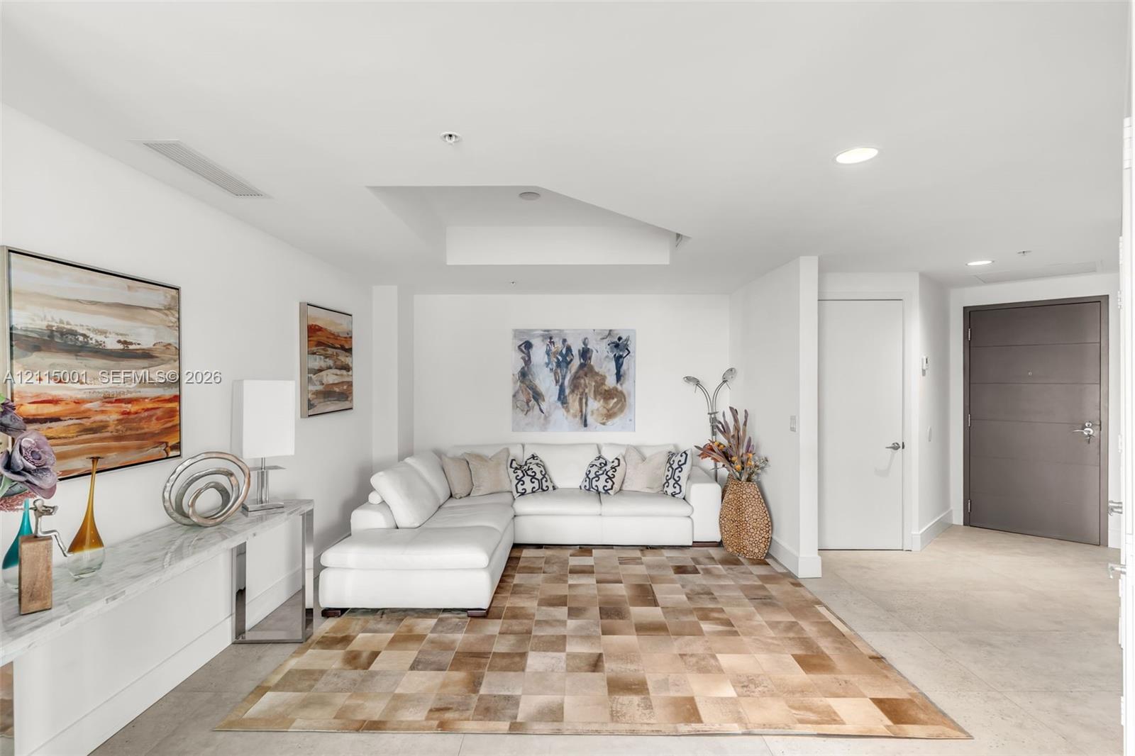 Living space featuring recessed lighting, a coffered ceiling detail, stone-top console cabinetry, and a solid-core entry door