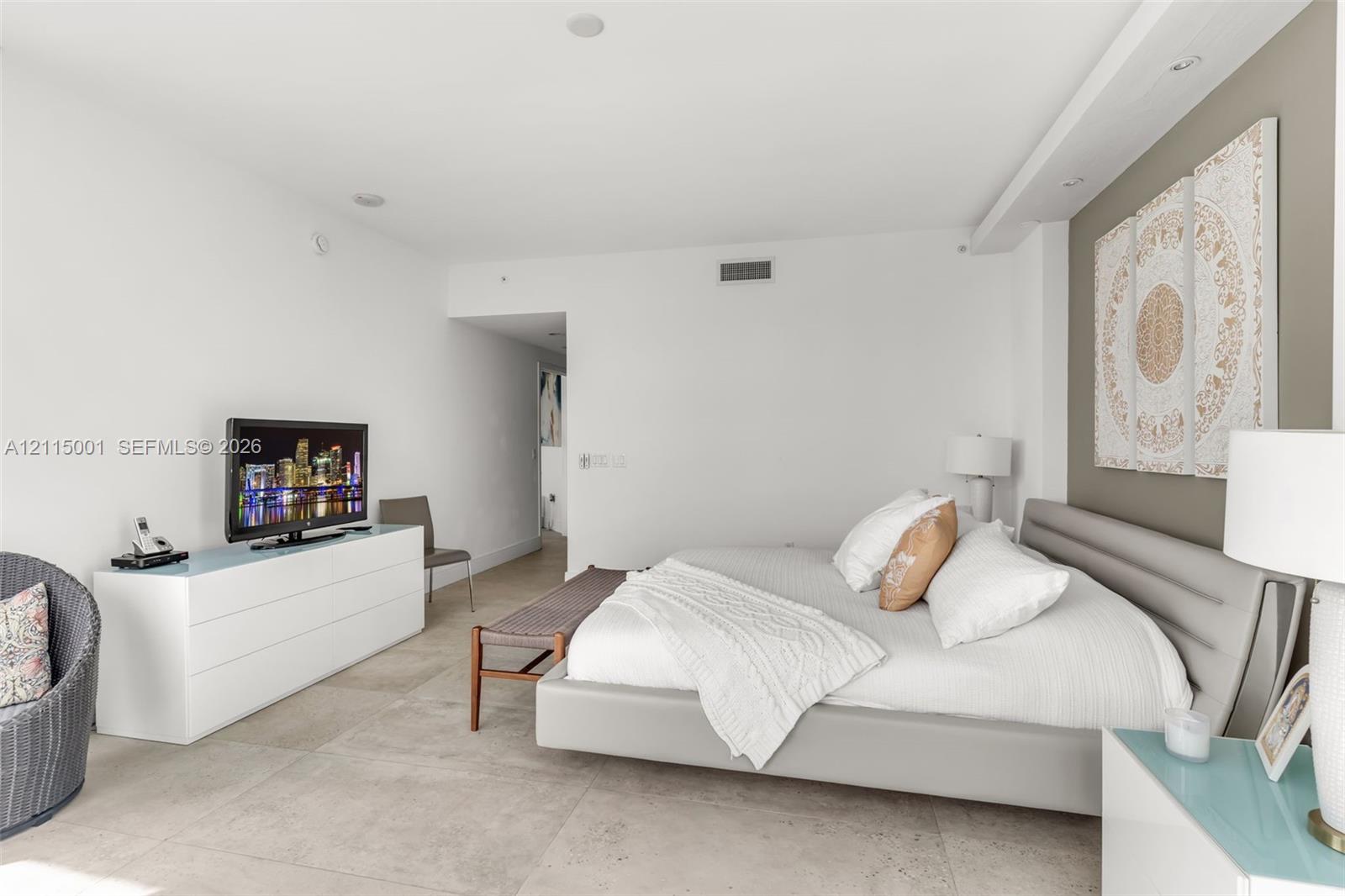Large-format tile flooring, recessed ceiling lighting, and a neutral-toned accent wall