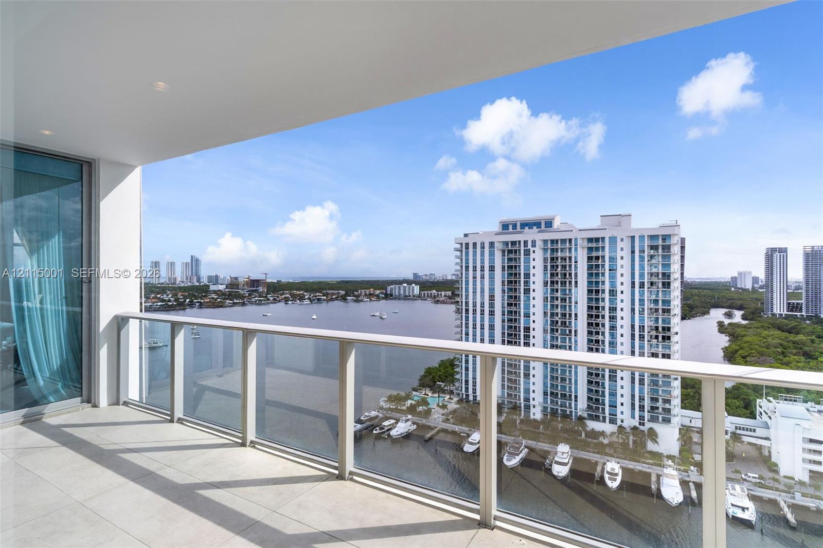 Covered balcony with large-format tile flooring and a glass-paneled railing