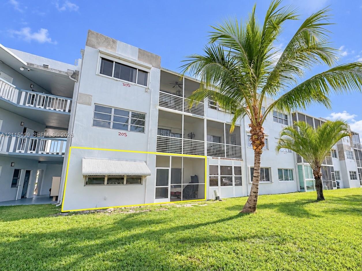 Ground-level unit featuring a screened-in lanai, retractable metal window awning, and exterior access