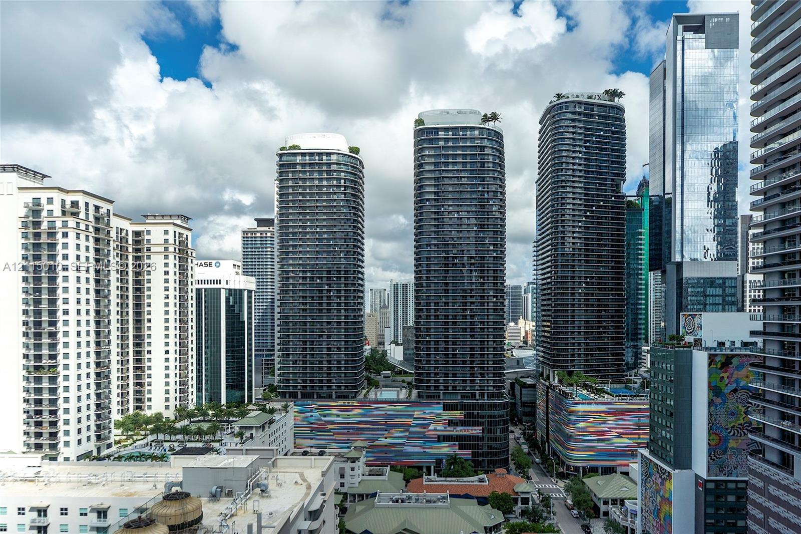 High-rise urban landscape featuring contemporary glass skyscrapers, private balconies, rooftop greenery, and colorful architectural facade accents