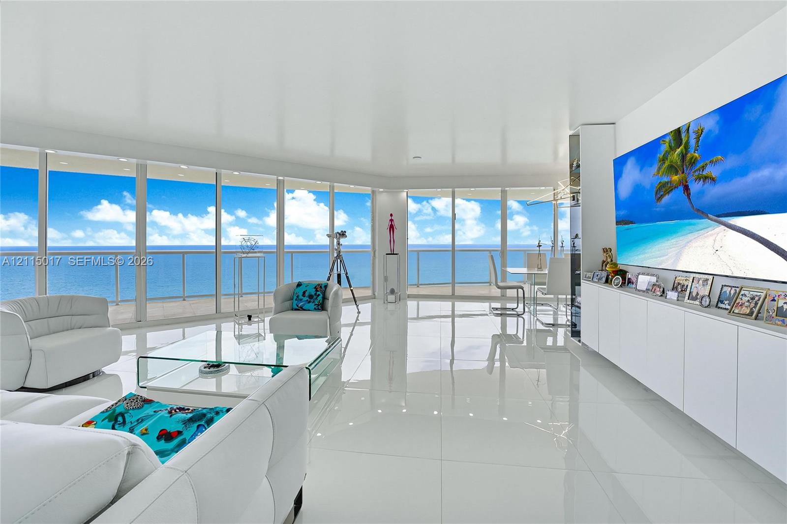 Floor-to-ceiling glass panel walls, expansive tile flooring, custom built-in white cabinetry, and recessed lighting