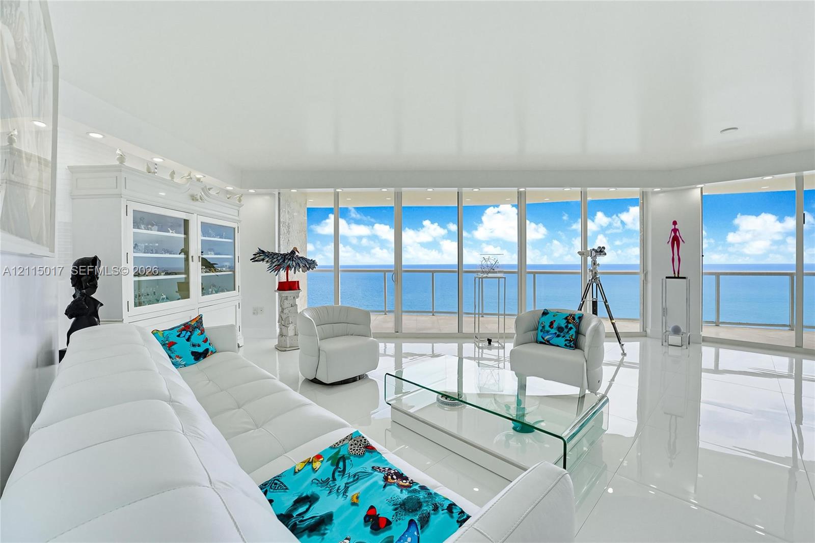 Floor-to-ceiling glass panel windows, wide-format polished tile flooring, built-in display cabinetry, and a wraparound balcony