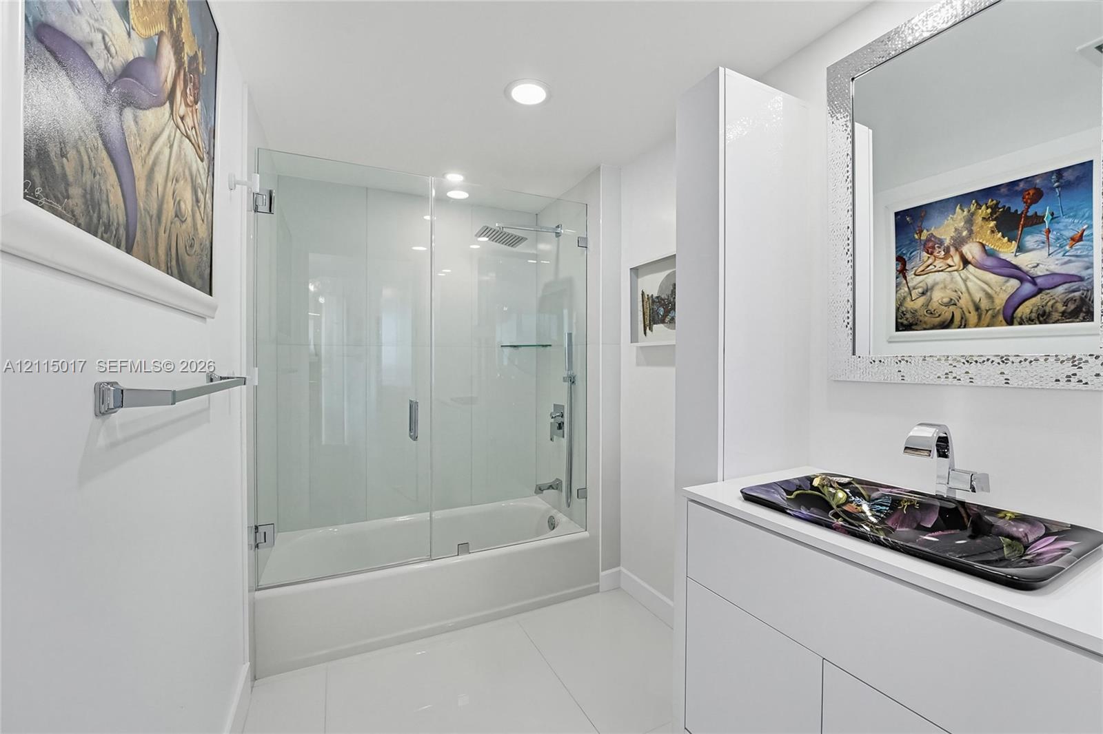 Bathroom featuring a glass-enclosed shower and tub combination, a white vanity with built-in cabinetry, a rectangular vessel sink, and chrome fixtures