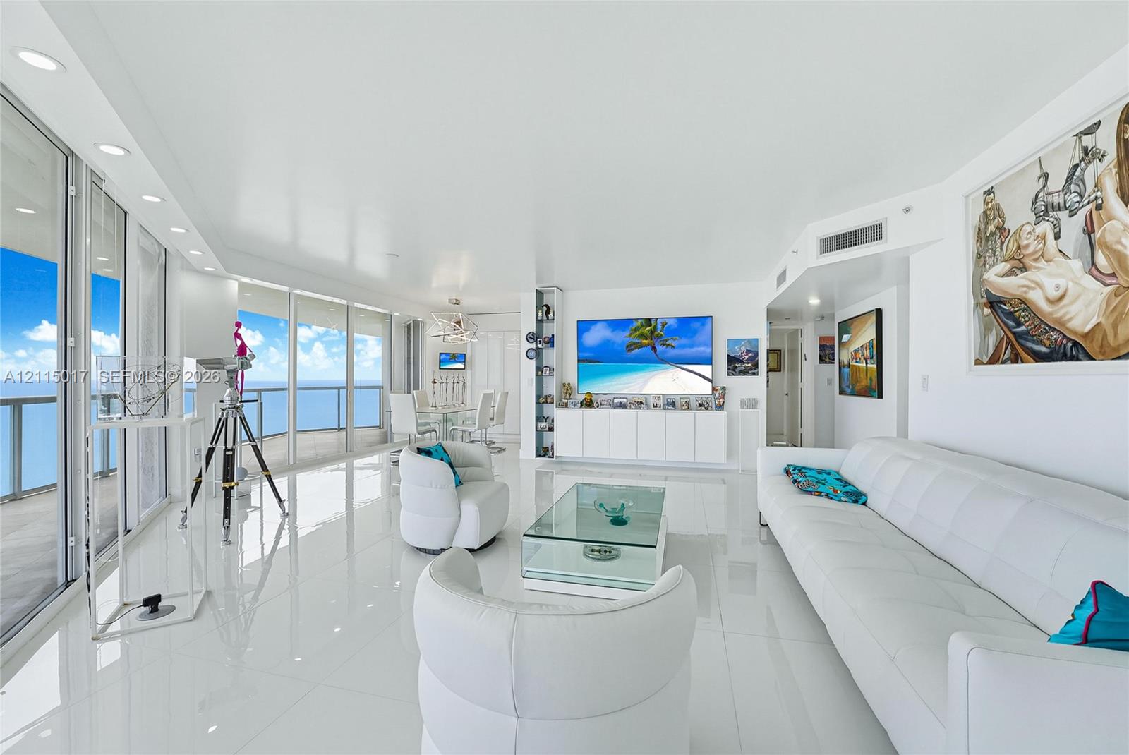 Living area featuring large-format tile flooring, floor-to-ceiling glass walls, recessed lighting, and custom built-in white cabinetry