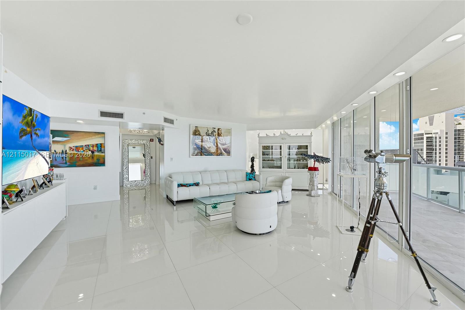 Open-concept interior featuring large-format polished tile flooring, floor-to-ceiling glass sliding doors, and recessed lighting
