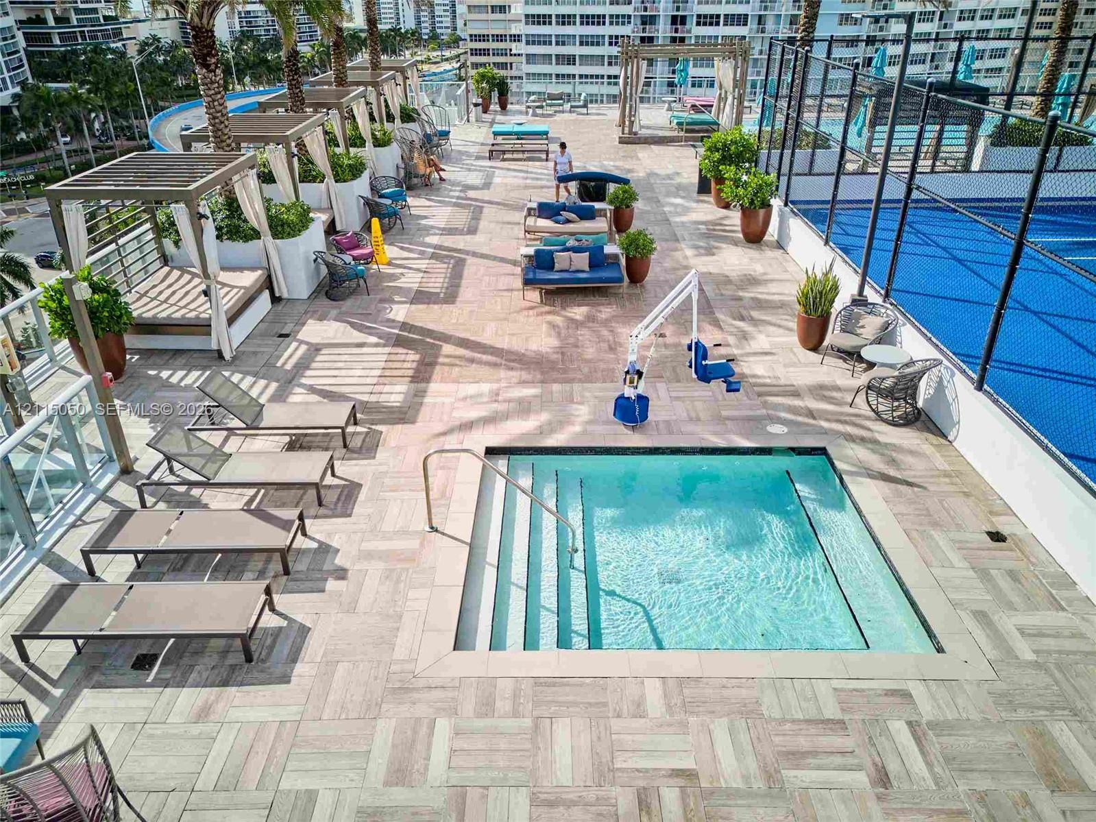 Rooftop terrace featuring a tiled deck, built-in swimming spa, court area, and multiple shaded cabanas