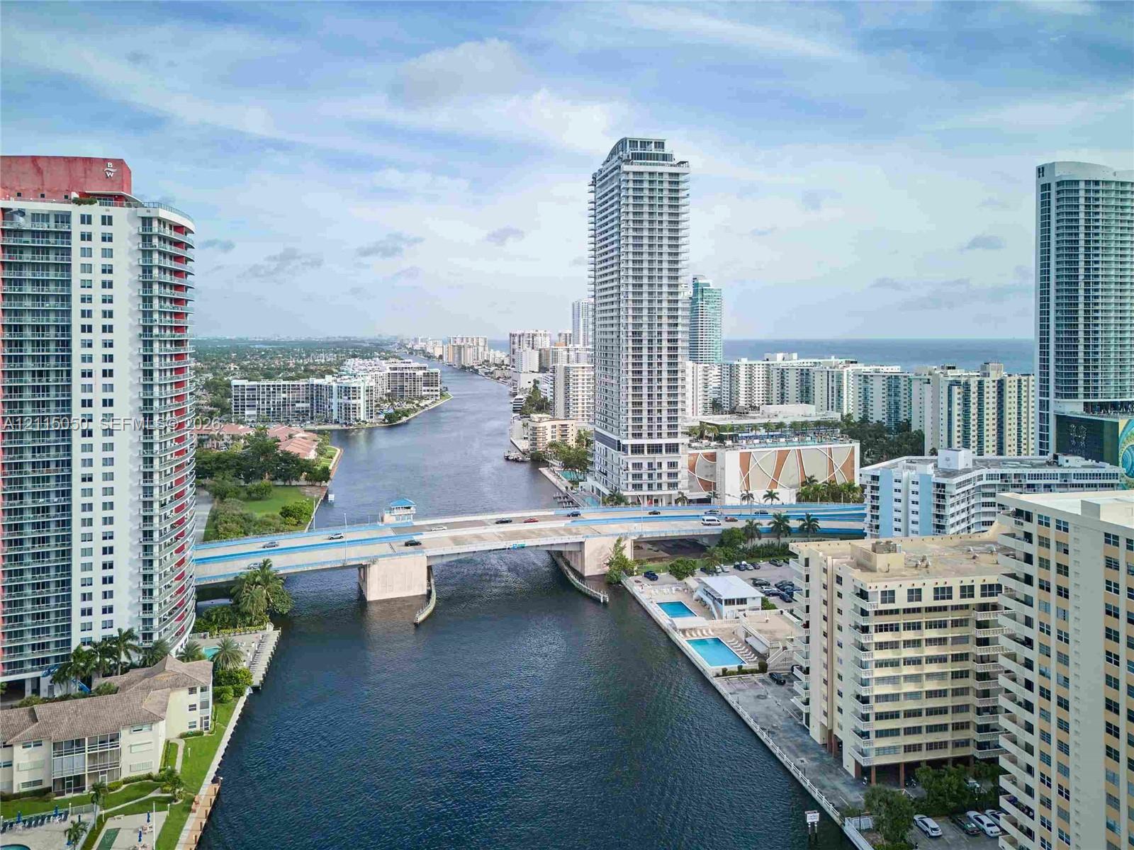 High-rise urban landscape featuring deep-water canal access, multiple multi-story residential towers, and a bridge infrastructure spanning the waterway