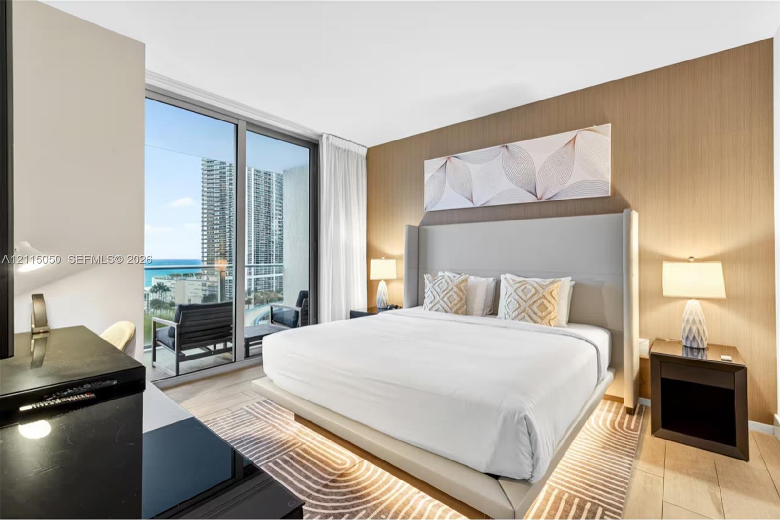Floor-to-ceiling glass sliding doors, wood-finish wall paneling, light-tone wood-finish flooring, and balcony access