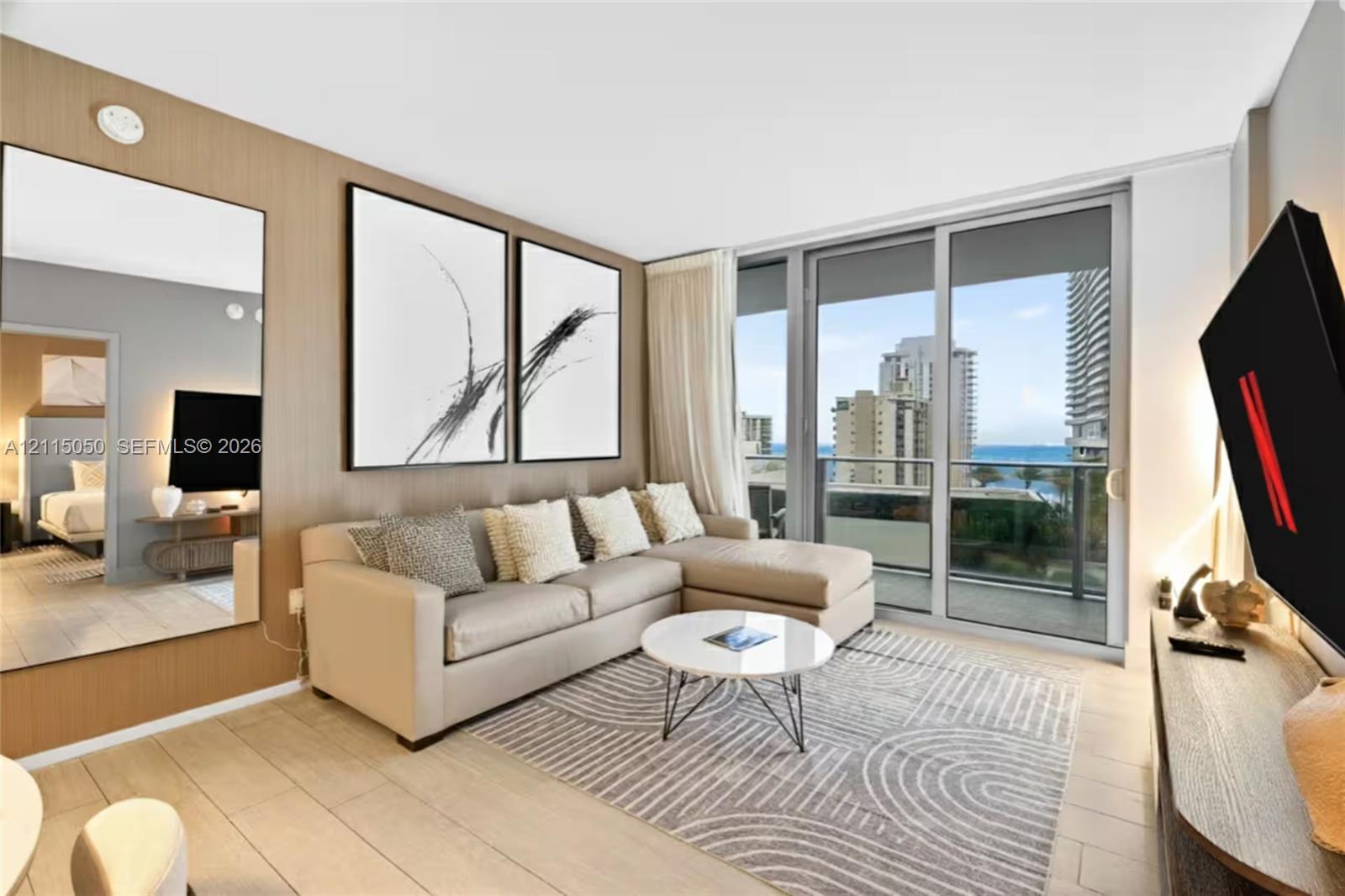 Wood-finish paneling, floor-to-ceiling glass sliding door, porcelain tile flooring, full-length wall mirror, and metal-framed balcony railing Wood-finish paneling, floor-to-ceiling glass sliding door, porcelain tile flooring, full-length wall mirror, and metal-framed balcony railing
