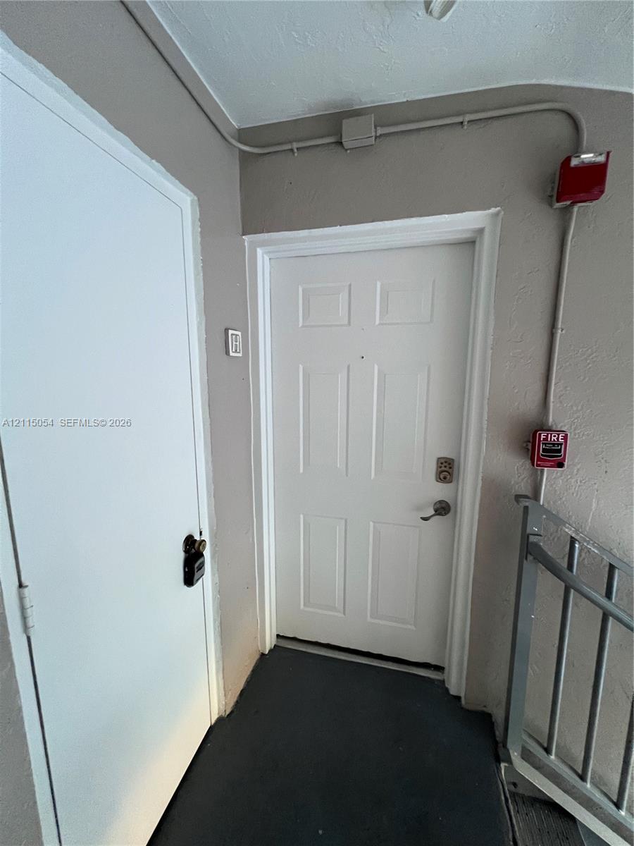 Six-panel entry door featuring a brushed metal keypad lock and peephole