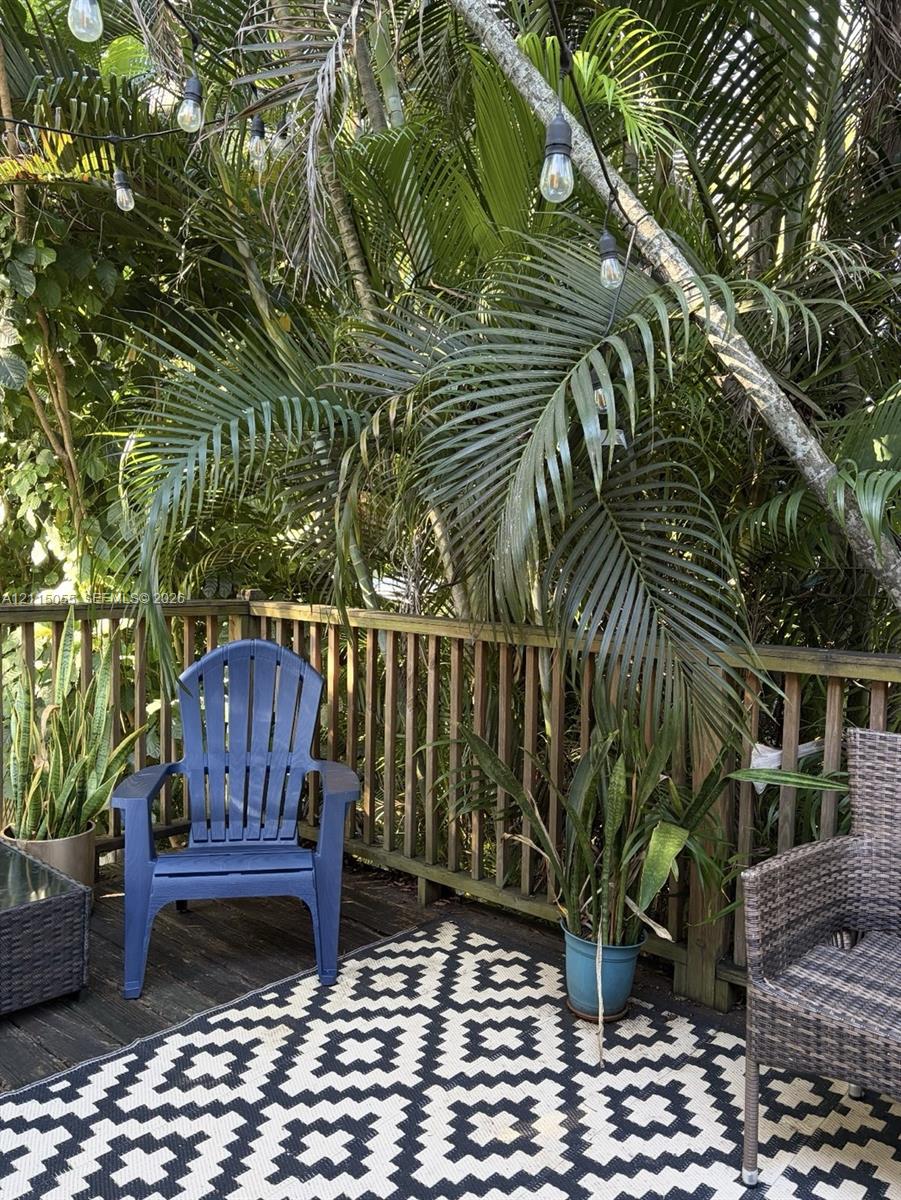 Outdoor deck featuring wood planking, vertical wood railing, and overhead string lighting