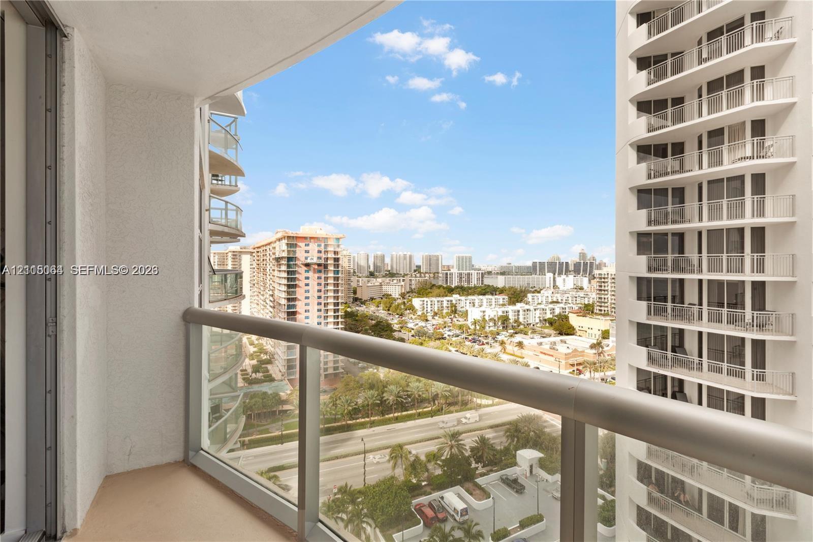 Private balcony featuring a glass-panel railing and concrete flooring