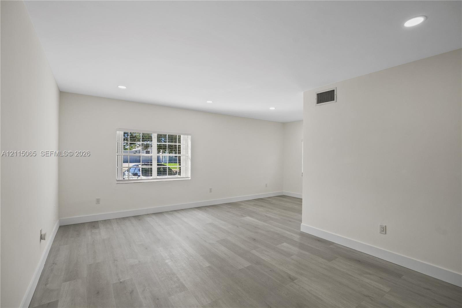 Interior space featuring neutral wall paint, wood-finish flooring, and recessed ceiling lighting
