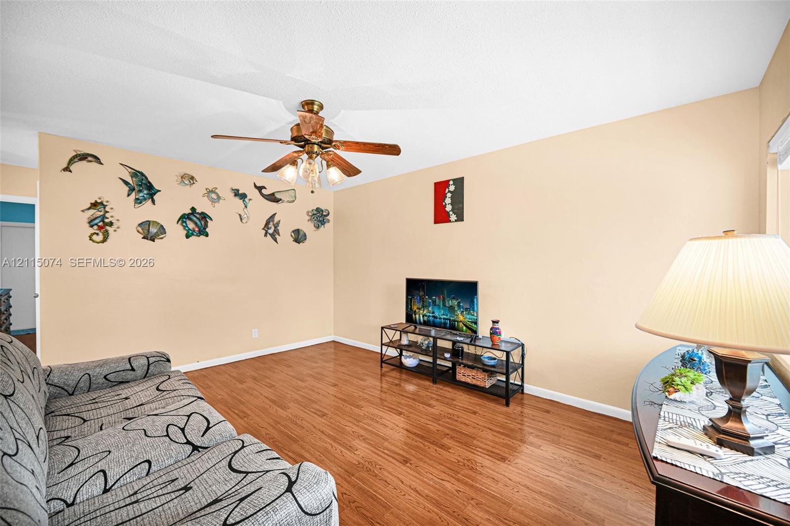 Wood-finish flooring and a central ceiling fan with integrated lighting