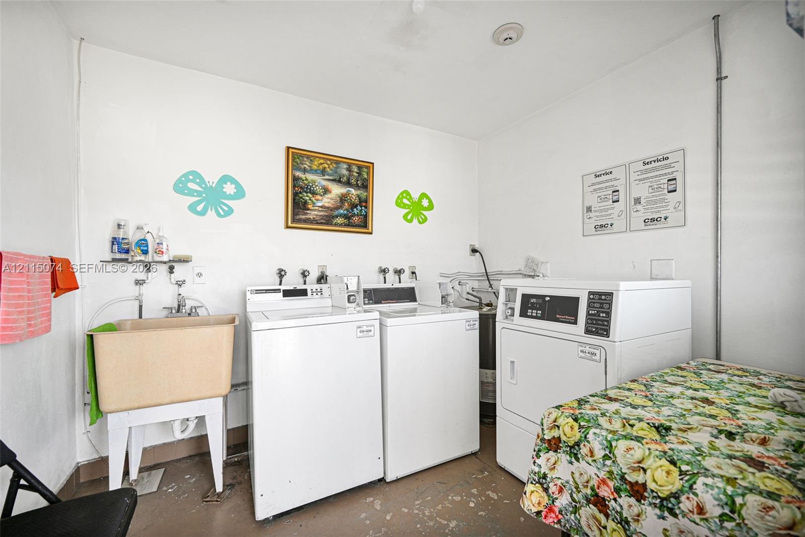 Laundry room featuring a utility sink with dual-handle faucet, wall-mounted shelving, and designated hookups for laundry appliances