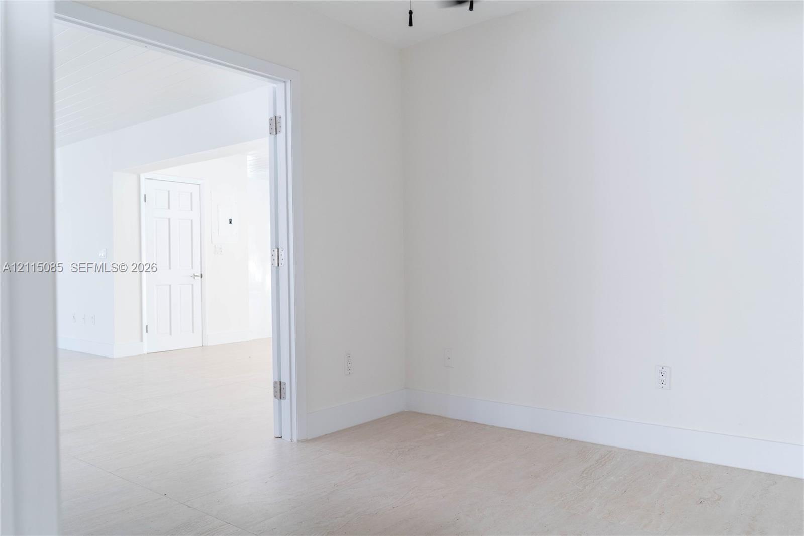 Neutral-toned walls, light-toned porcelain tile flooring, and a six-panel interior door