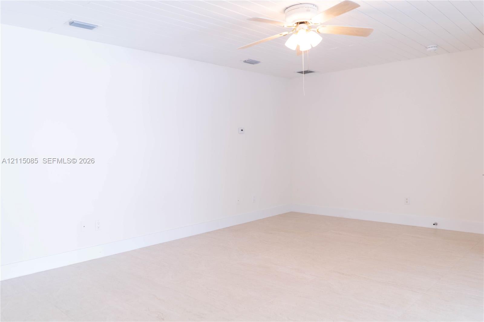 Plank-style ceiling, light-toned porcelain tile flooring, and integrated ceiling fan with multi-light fixture