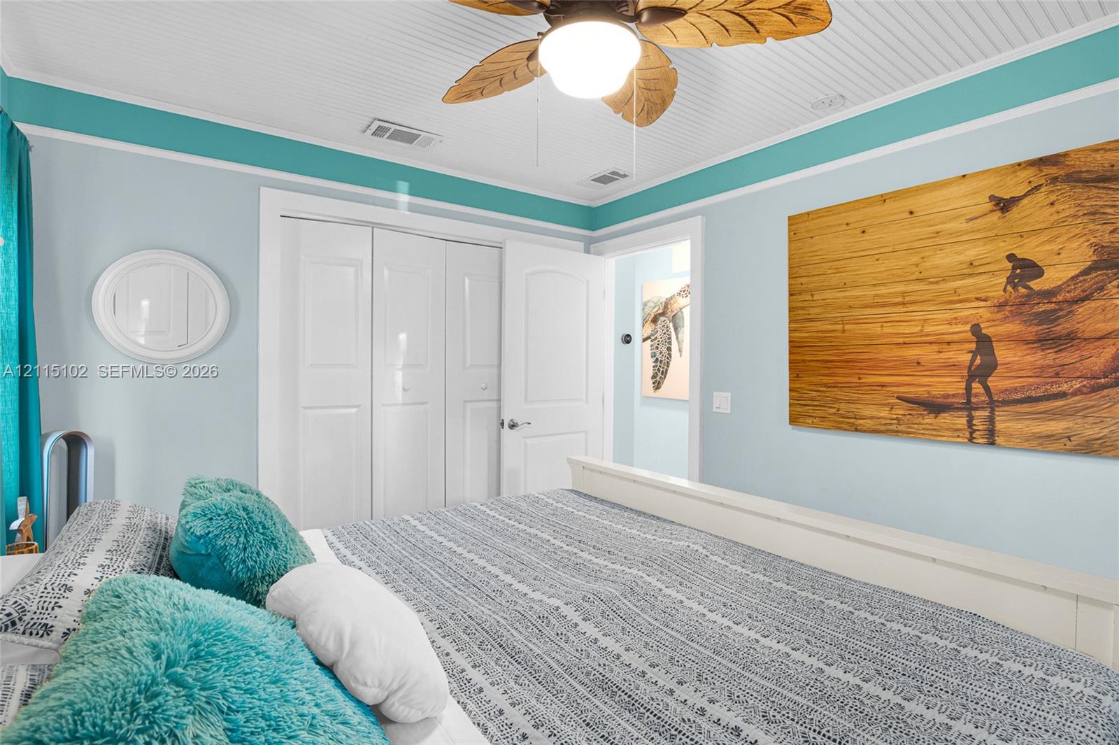Beadboard ceiling featuring a central palm-style ceiling fan, bi-fold closet doors, and multi-panel interior door