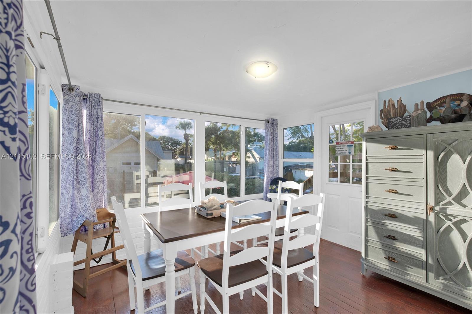 Sunroom featuring multiple large windows, wood-finish flooring, and a multi-pane glass-panel entry door