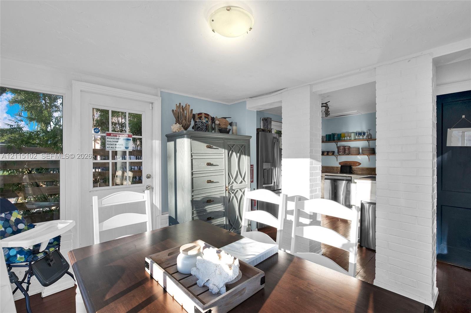 Multi-pane glass-panel exterior door, painted brick column architectural feature, and wood-finish flooring