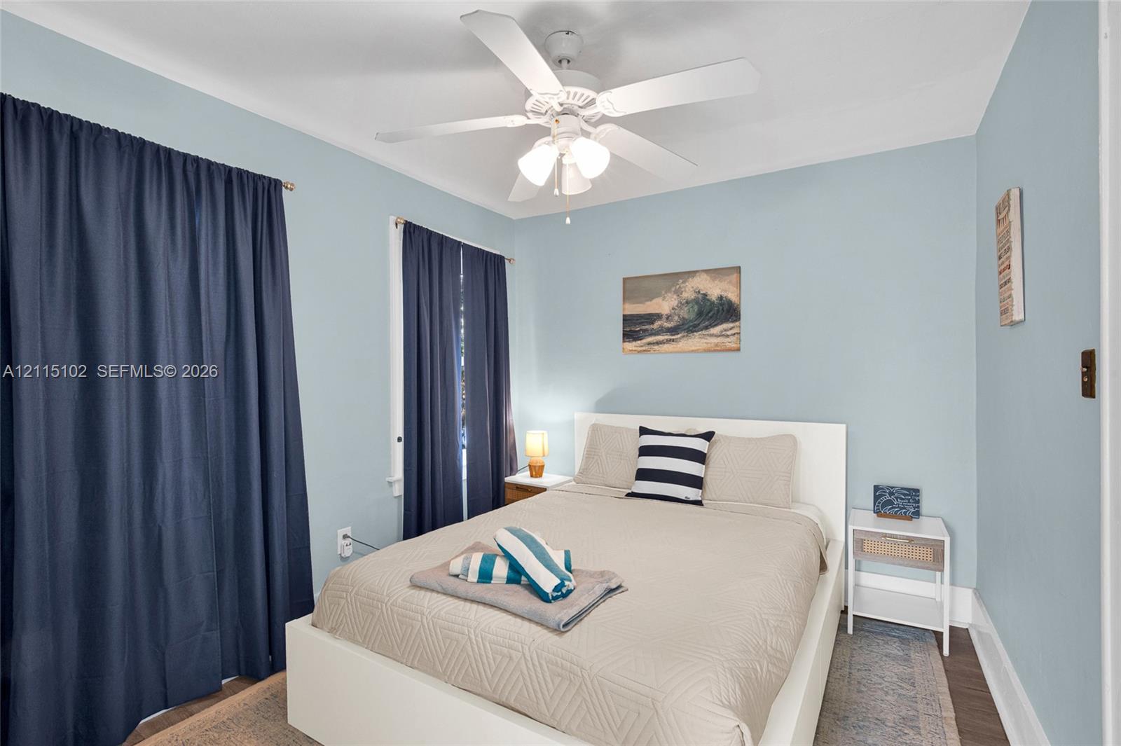 Bedroom featuring wood-finish flooring and a central ceiling fan with integrated lighting