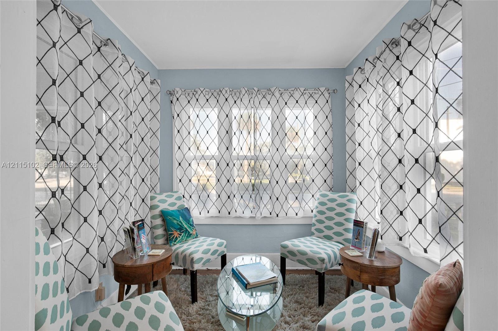 Sunroom featuring multi-pane window configurations, pale blue wall finishes, and clean architectural lines