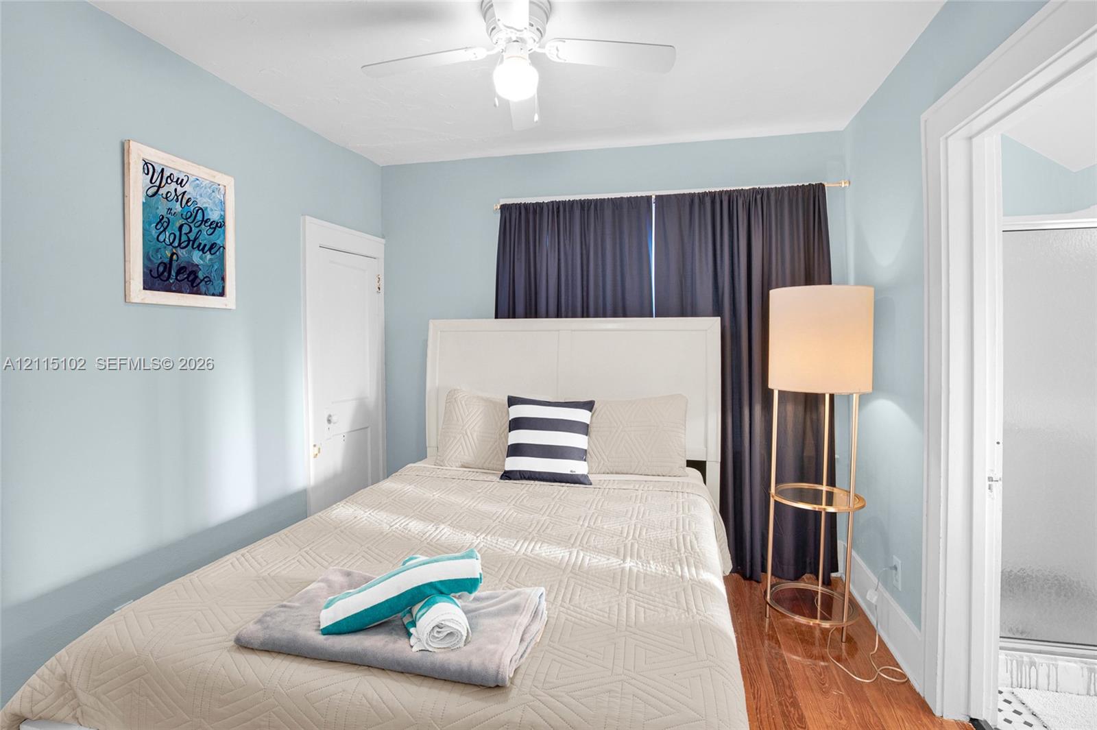 Interior space featuring hardwood flooring, multi-panel interior door, and ceiling-mounted light fixture with fan