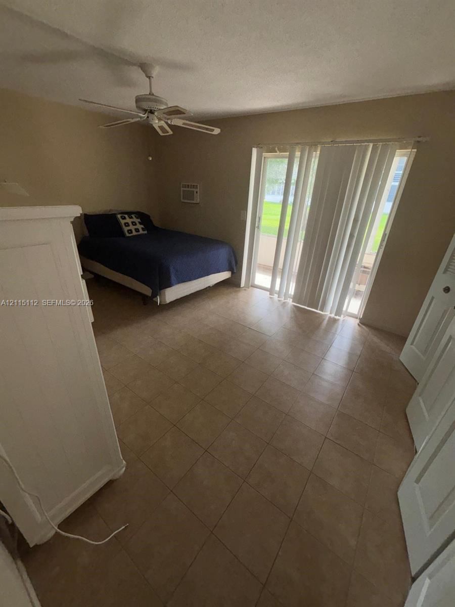 Tile flooring, ceiling fan, and sliding glass doors providing outdoor access