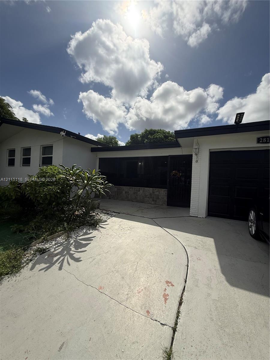 Single-story exterior featuring white masonry facade, stone accent detailing, dark-toned trim, and an attached garage Single-story exterior featuring white masonry facade, stone accent detailing, dark-toned trim, and an attached garage