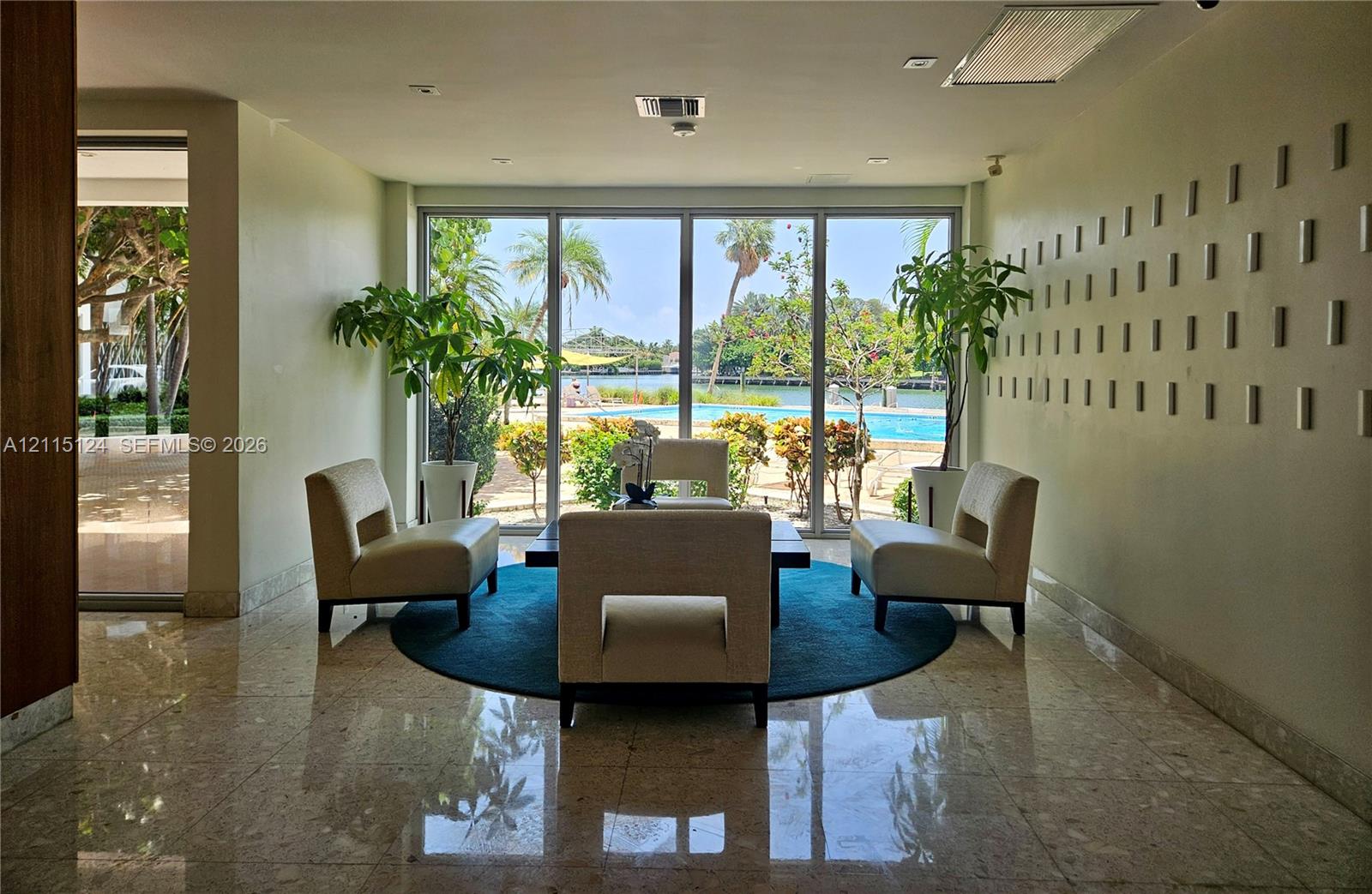Floor-to-ceiling glass windows, polished stone flooring, and textured wall accents, complemented by an outdoor swimming pool and water frontage Floor-to-ceiling glass windows, polished stone flooring, and textured wall accents, complemented by an outdoor swimming pool and water frontage