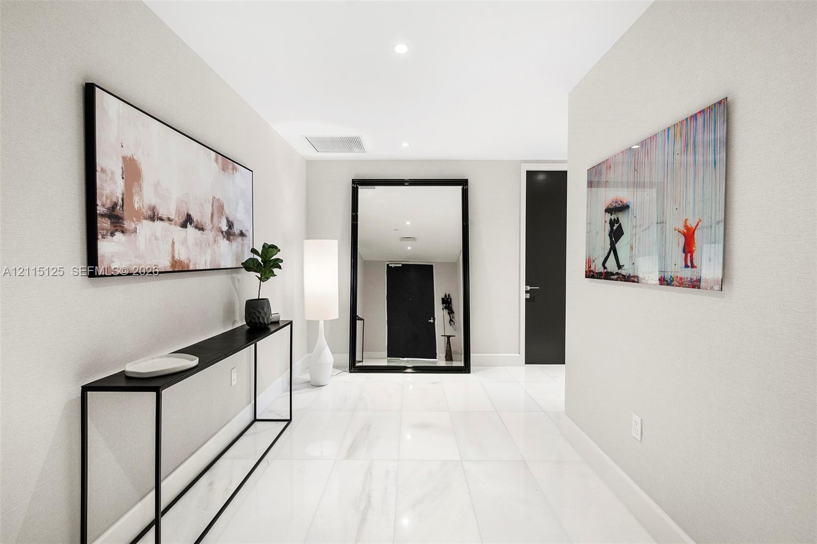 Foyer featuring large-format polished tile flooring, neutral wall tones, and recessed lighting