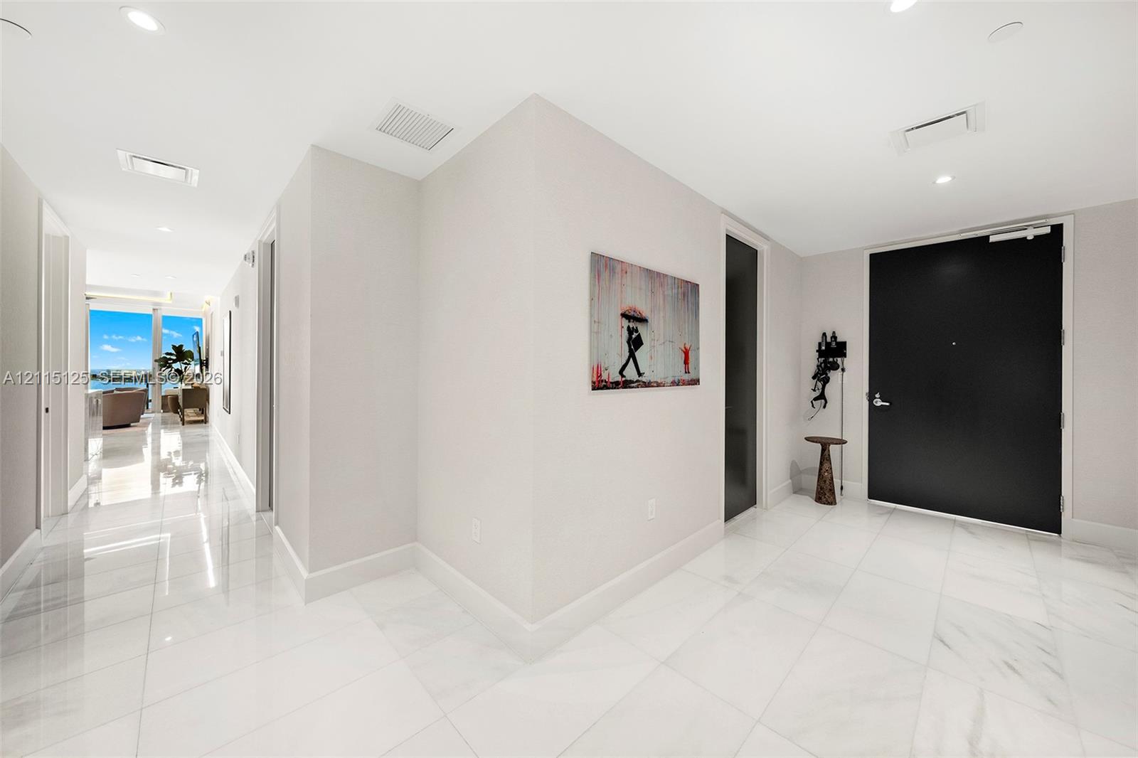 Entryway featuring polished stone flooring, recessed lighting, and a solid black entry door
